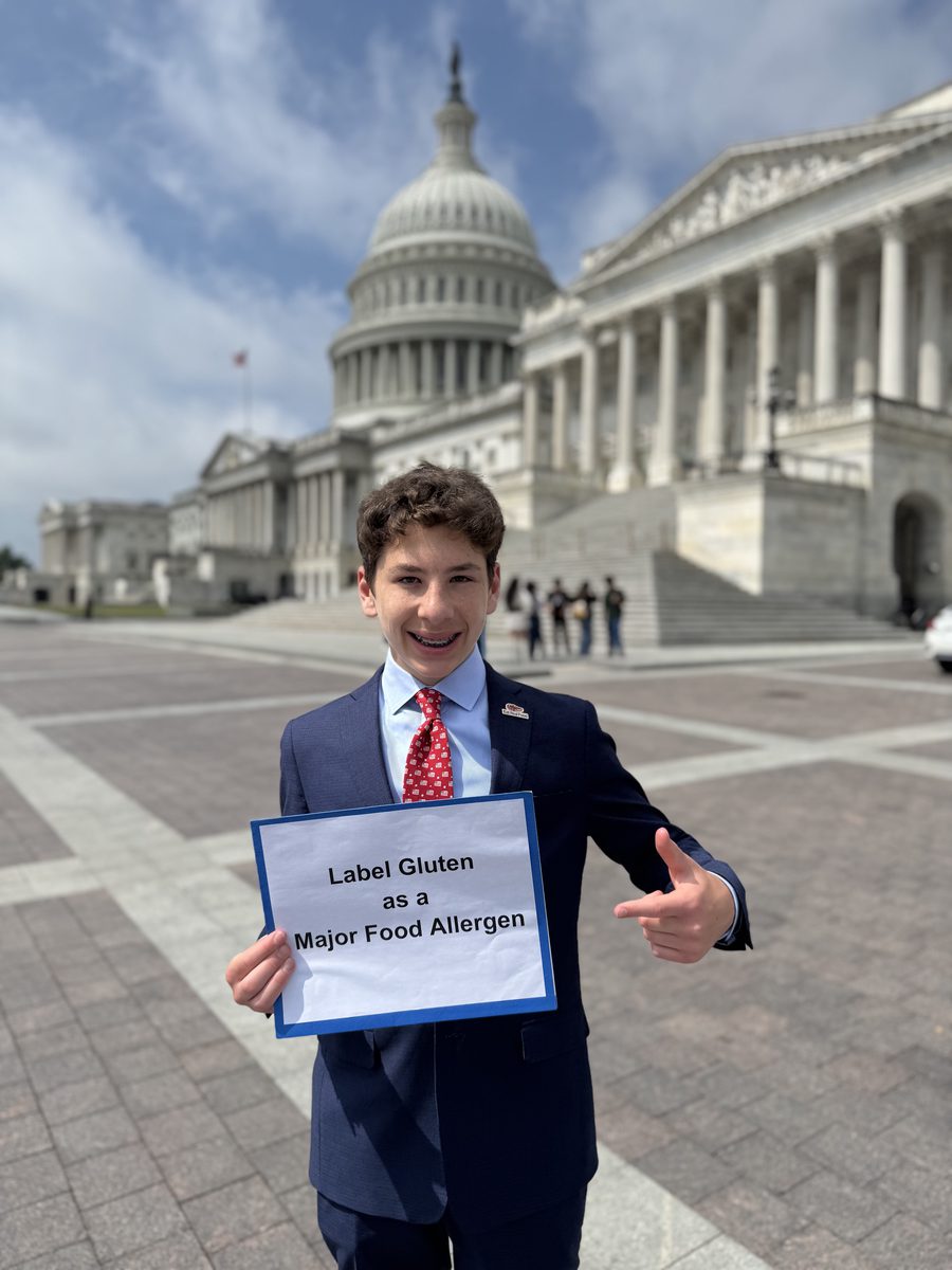Jax Bari holding a sign reading Label Gluten as a Major Food Allergen outside the United States Capitol