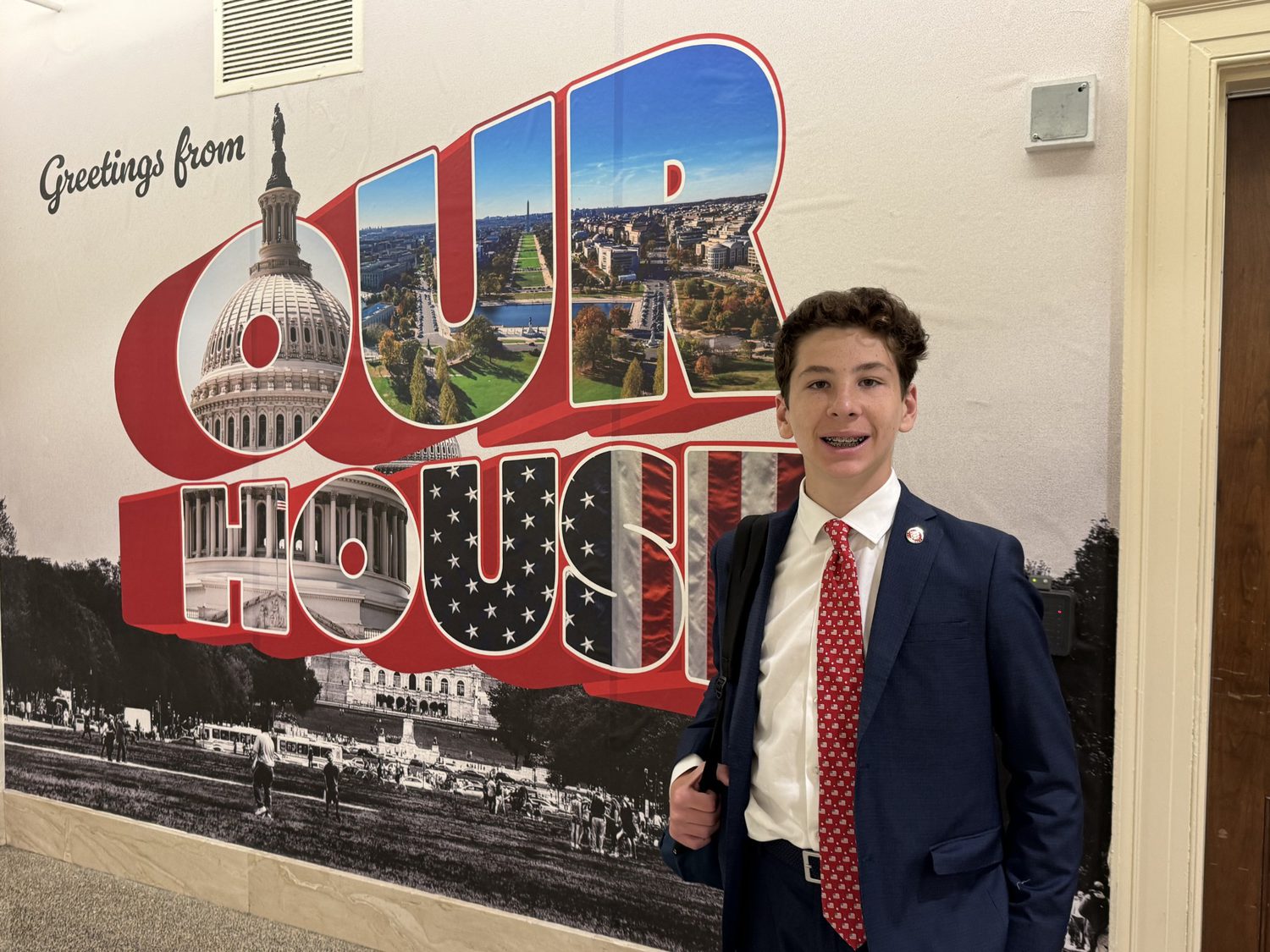 Jax Bari standing in front of the Greetings from Our House mural at the United States Capitol